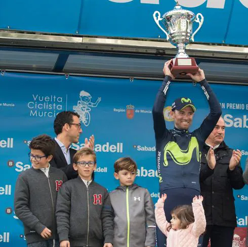 Valverde alza el trofeo de ganador junto a sus hijos.