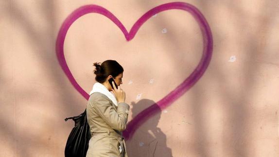Una mujer pasa ante una fachada decorada con un corazón. 