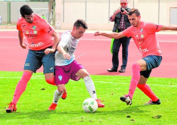 Álvaro Romero intenta irse del marcaje de dos jugadores de El Ejido.