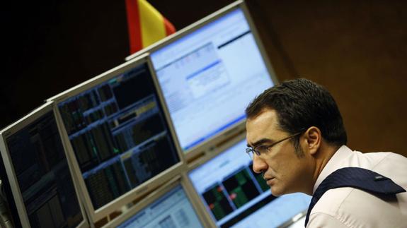 Un operador de un fondo de inversión observa la evolución de la Bolsa española. 