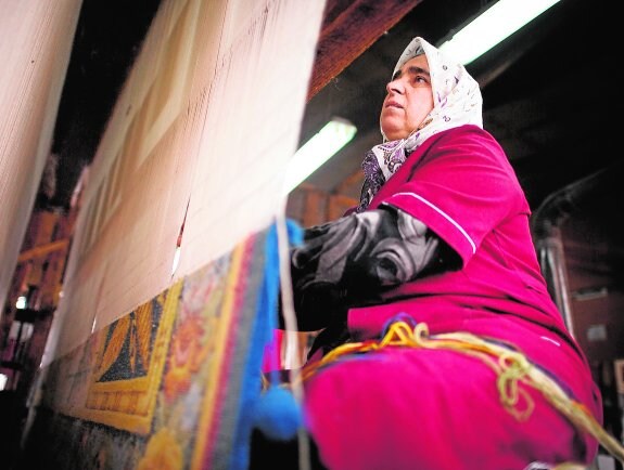 Una tejedora trabaja en una alfombra en el taller de Nino Parpulov, en Kostandovo.