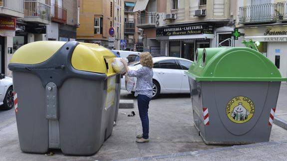 Una mujer utilizando un contenedor de reciclaje en Murcia.