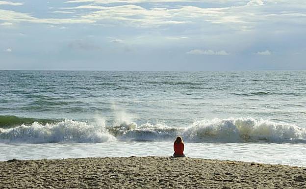 Una mujer observa el Atléntico desde una playa de Florida.