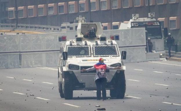 Una anciana, delante de un blindado antidisturbios.