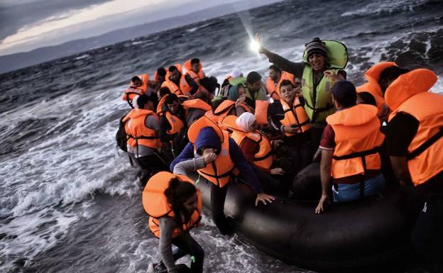 Refugiados sirios arriban en una barca neumática a las costas de la isla griega de Lesbos.