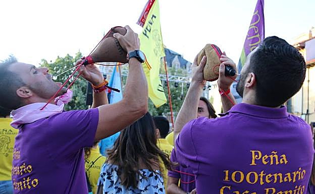 Imagen. Dos peñistas bebiendo de una bota de vino.