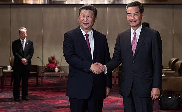 Xi Jinping (izq.) saluda a Leung Chun-ying.