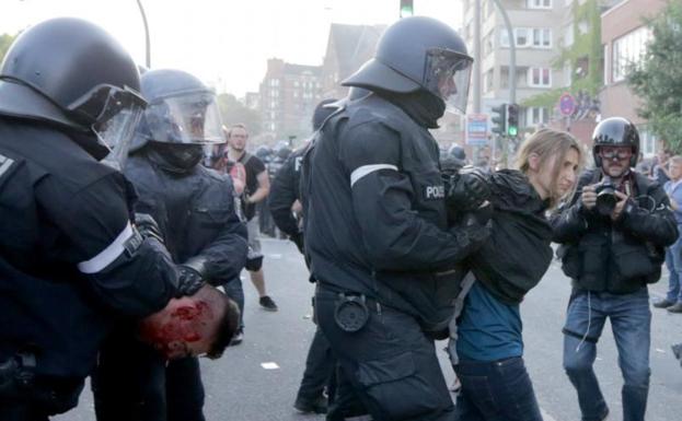 Agentes de Policía detienen a dos manifestantes en Hamburgo.