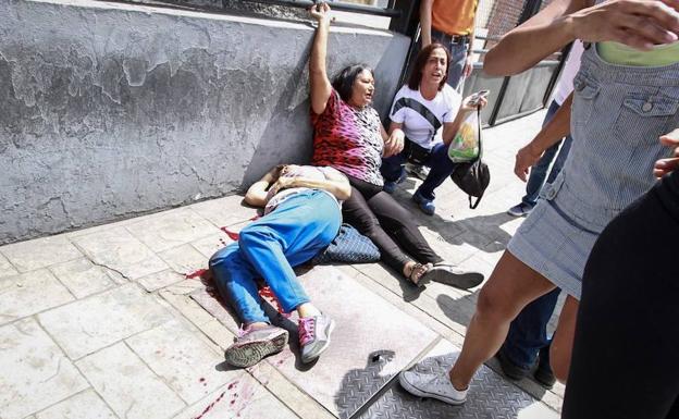 Dos mujeres yacen en el suelo después de un enfrentamiento. 