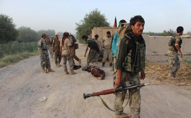 Personal de seguridad afgana, junto a un cuerpo.