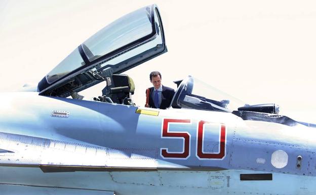 Bachar El-Asad observa la cabina de un avión de combate mientras visita la base militar rusa en Latakia (Siria).