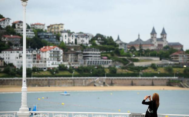 Turista saca una fotografía de la playa de La Concha, en San Sebastián.