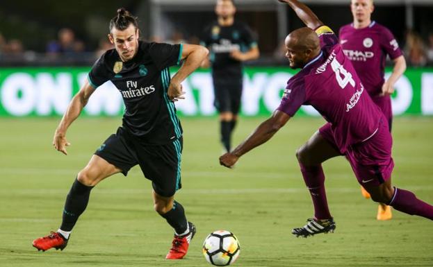 Bale disputa el balón a Vincent Kompany.