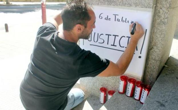 Los familiares de los mineros del Pozo Emilio colocan un cartel en los Juzgados de León. 