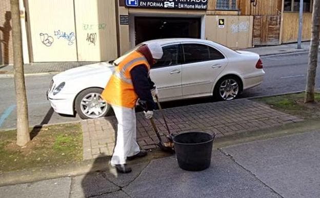 Un operario del servicio de limpieza barre una calle en Ponferrada.