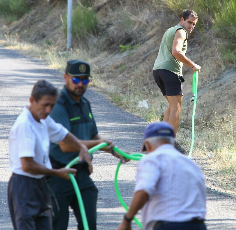 Vecinos de Santa Eulalia de La Cabrera desalojados de sus viviendas por la amenaza del fuego.