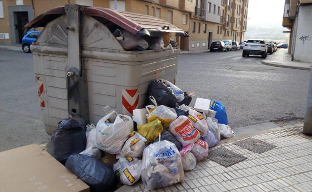 Basura acumulada junto a contenedor en una calle de Ponferrada.
