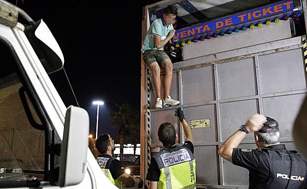 Miembros de la Policía desalojan a un menor de una atraccíon.