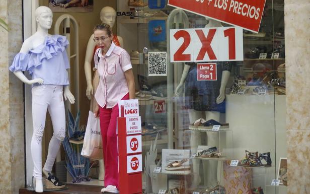 Una clienta sale de una tienda 