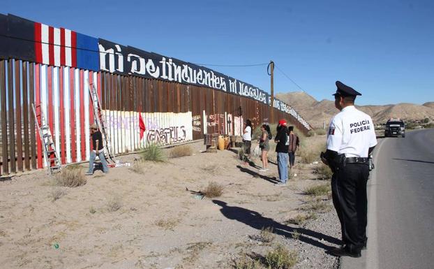 Un policía federal vigila un muro en Ciudad Juárez. 