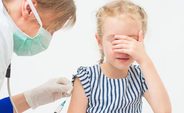 Una niña a punto de ser vacunada.