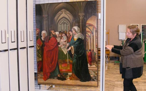 Una trabajadora del Museo de Zaragoza muestra una de las tablas.