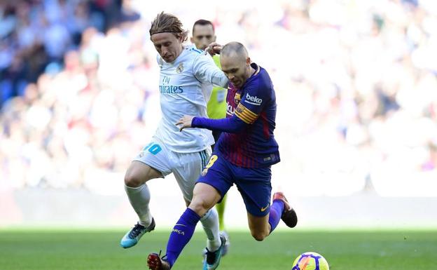 Iniesta, en una disputa ante Luka Modric.