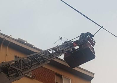 Imagen secundaria 1 - Los Bomberos cortan la calle López de Fenar para poder retirar placas de hielo de los tejados