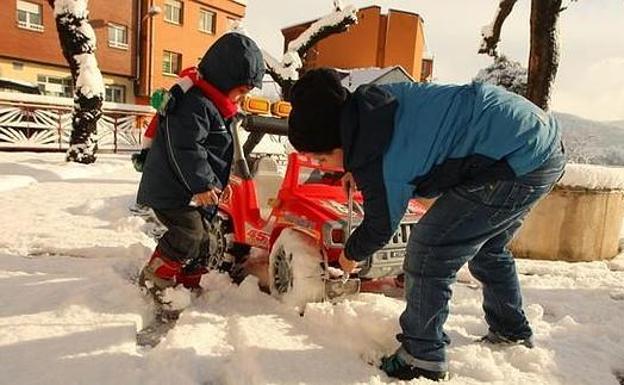 Dos niños juegan con la nieve en Toreno.