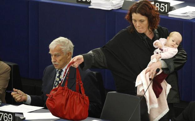 Una europarlamentaria danesa vota en una sesión del Parlamento Europeo mientras vigila a su bebé. 