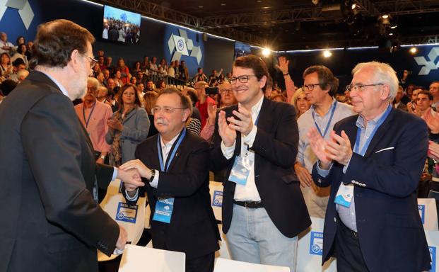 El presidente del PP de Castilla y León, Alfonso Fernández Mañueco, saluda al presidente nacional del partido, Mariano Rajoy, antes de intervenir en la mesa Diálogos Populares en la Convención Nacional.