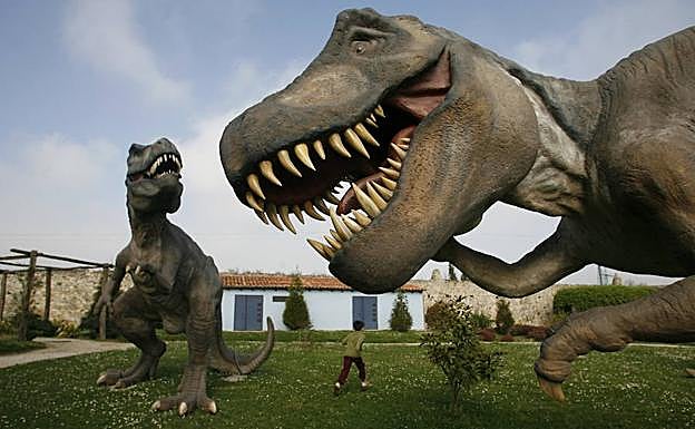 Niño contempla algunos de los 16 gigantes prehistóricos a tamaño real que se explonen en el Parque Dinosaurio, en Santillana del Mar. 