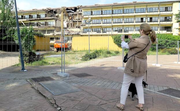 Una mujer fotografía la demolición. 