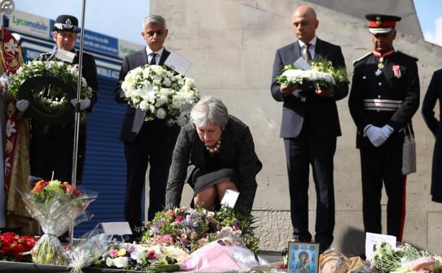 May deposita unas flores durante el homenaje a las víctimas.