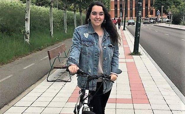 La estudiante junto a su bici.