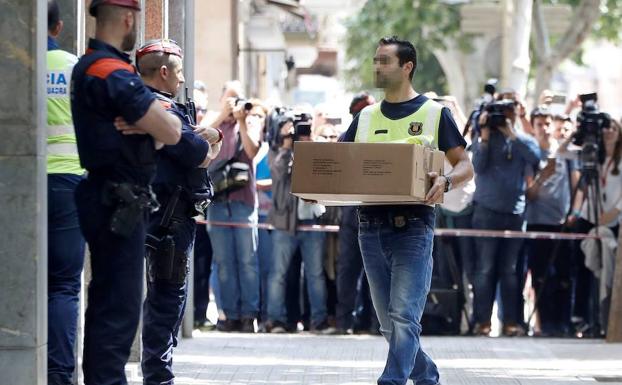 Investigadores de los Mossos, durante el registro de la vivienda del detenido.