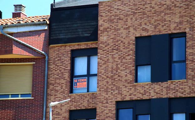 Una vivienda con un cartel de venta.