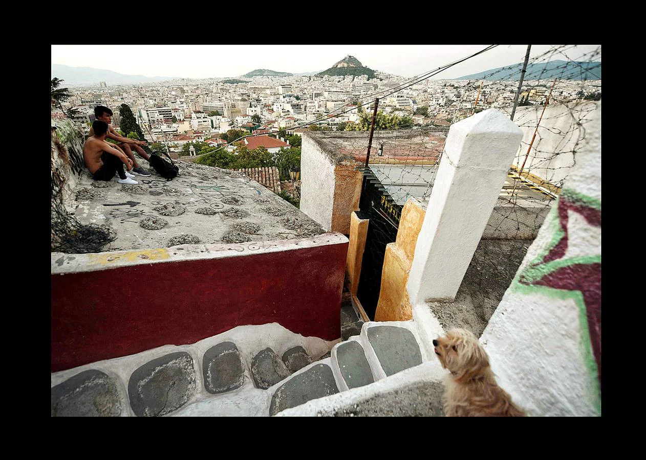 El distrito de Anafiotika, en Atenas, tiene el aire de un pintoresco pueblo de piedra sacado de las islas Cícladas, pero se encuentra a los pies de la Acrópolis. Quien ascienda por las estrechas y sinuosas calles del distrito de Plaka se sorprenderá ante la vista de un pueblo casi idéntico a los de las islas del mar Egeo. De hecho, las cien casas con techos de tejas, conocidas como Anafiotika, son tan antiguas como la capital griega moderna. Y es que para devolver a la ciudad su gloria clásica tras la guerra contra el imperio Otomano, el rey de Grecia invitó a los mejores canteros de la isla egea de Anafi a trabajar en su reconstrucción.