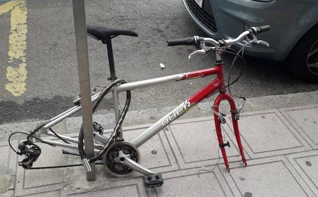 Bicicleta, a la que le han desvalijado las ruedas, en plena avenida Padre Isla. 