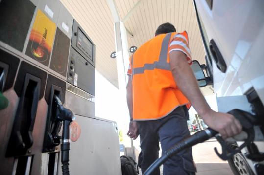 Un hombre llena el depósito de un vehículo en una gasolinera.