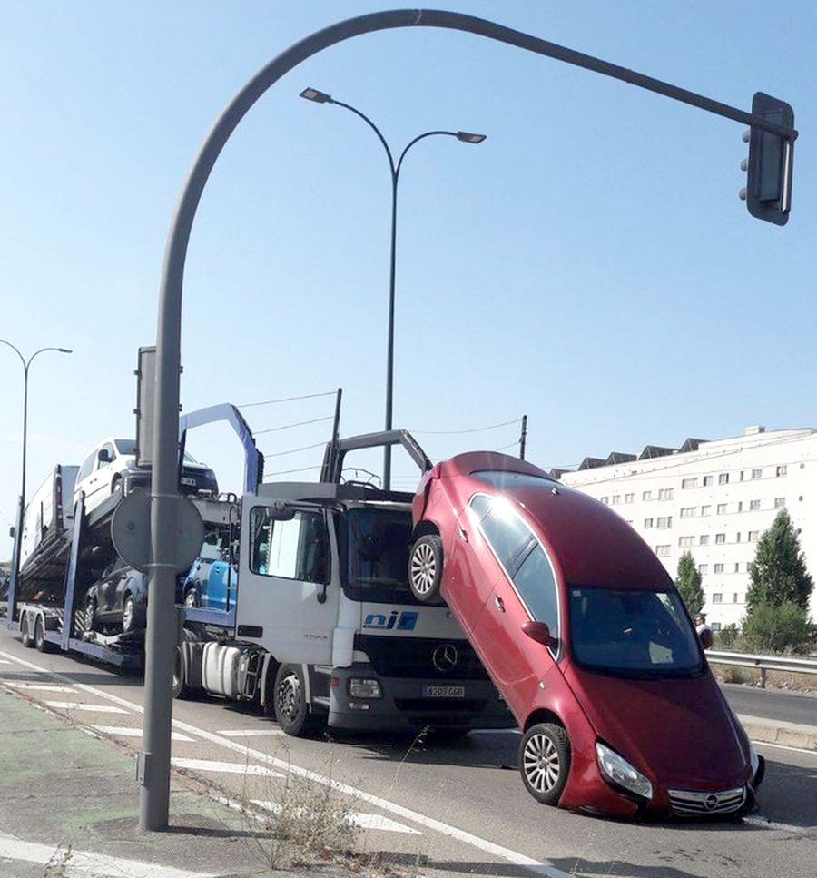 Un coche se cae de un camión portavehículos en un semáforo de la avenida de Madrid, en Valladolid