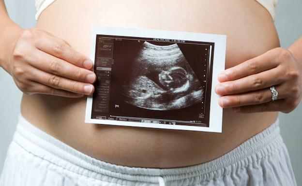 Una embarazada muestra su ecografía.