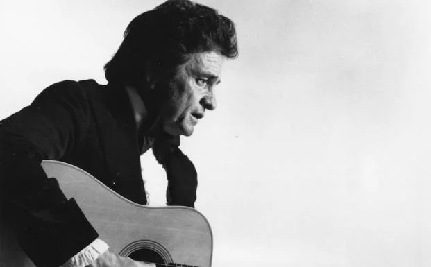 Johnny Cash toca la guitarra.
