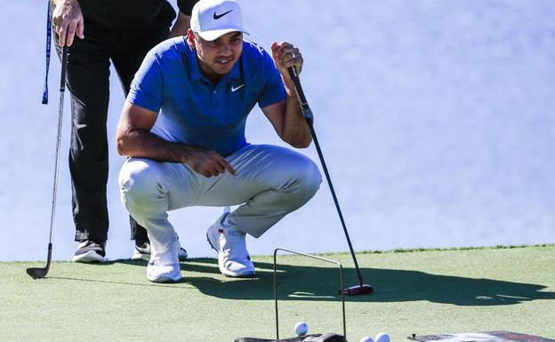 Jason Day y su entrenador preparan su golpe durante una práctica de golf en Atlanta