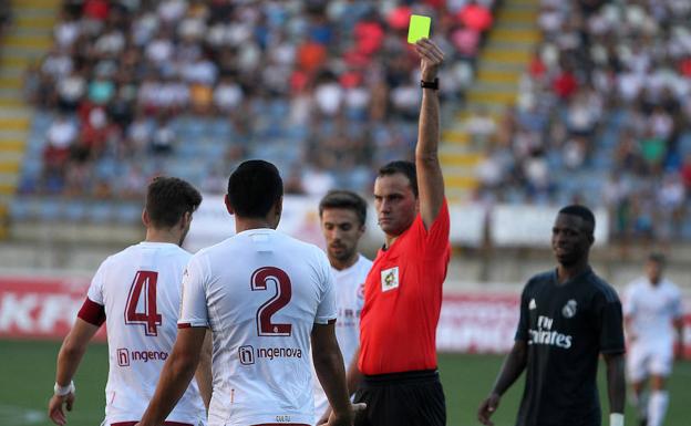 El árbitro amonesta a un jugador de la Cultural.