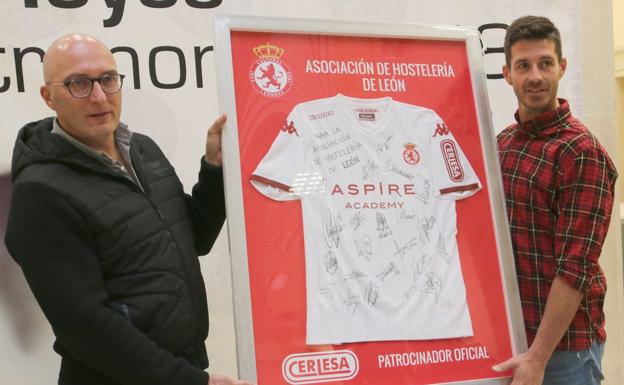 Jorge Palatsí, portero de la Cultural, entrega una camiseta firmada por todos los jugadores del club leonés al presidente de la Asociación de Hosteleros de León, Martín Méndez.