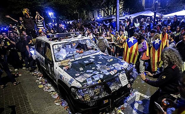 Imagen de archivo de un coche patrulla de la Guardia Civil destrozado por los partidarios del referéndum a la puerta de la Consejería de Economía de la Generalitat. 