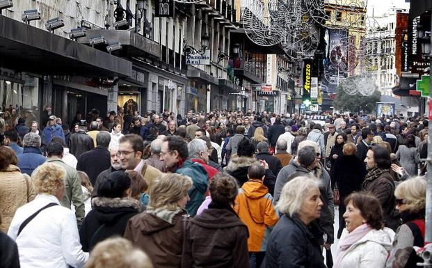 Numerosas personas caminan por una calle céntrica de Madrid. 