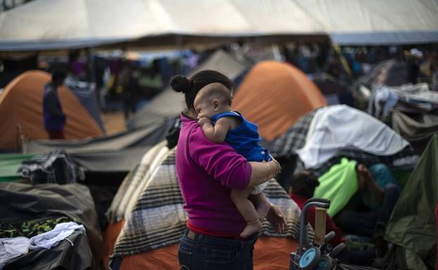 Una mujer migrante centroamericana sujeta a su bebé en un refugio temporal en Tijuana, México, cerca de la frontera con los Estados Unidos.