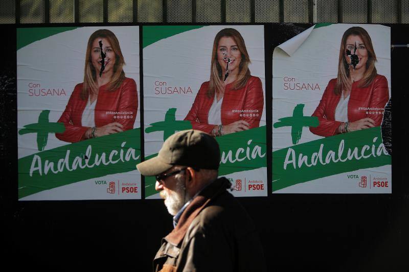 Un hombre pasea este domingo en Ronda (Málaga) frente a varios carteles electorales del PSOE con su candidata, Susana Díaz, como protagonista.